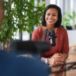 Smiling woman speaking into a microphone.